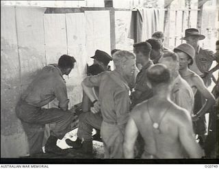 MOMOTE, LOS NEGROS ISLAND, ADMIRALTY ISLANDS. 1944-03-08. BARE-CHESTED RAAF KITTYHAWK PILOTS BEING BRIEFED IN THEIR CREW ROOM ON MOMOTE STRIP BEFORE AN OPERATION OVER THE ADMIRALTYS