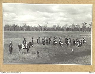 WONDECLA, QLD. 1944-04-15. THE COMMANDING OFFICER OF THE 2/1ST INFANTRY BATTALION NX163 LIEUTENANT COLONEL P.A. CULLEN, DSO. (2), WITH THE BATTALION BAND AT HIS LEFT HAND SIDE, WITH HIS ADJUTANT, ..