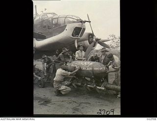 VIVIGANI, GOODENOUGH ISLAND, PAPUA. 1943-11-17. ARMOURERS OF NO. 8 (BEAUFORT) SQUADRON RAAF COMMANDED BY WING COMMANDER G. D. NICOLL, CHALK THEIR VISITING CARD ON A 2000LB DAISY-CUTTER BEING LOADED ..