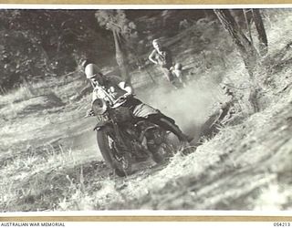 HERBERTON, QLD. 1943-07-09. NX26780 SERGEANT L.C. FLOOD, RIDING A MOTOR CYCLE GOING UP A STEEP HILL, DURING A TRAINING COURSE AT HEADQUARTERS, 6TH AUSTRALIAN DIVISION