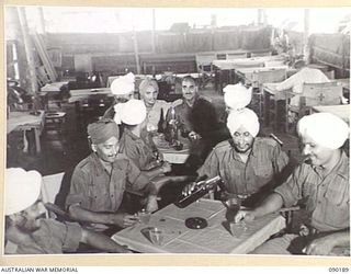 AITAPE, NEW GUINEA. 1945-03-29. A GROUP OF INDIAN SOLDIER PATIENTS ENJOYING A CUP OF CORDIAL IN THE RED CROSS HUT AT 104 CASUALTY CLEARING STATION. THE MEN, LIBERATED PRISONERS OF WAR WERE CAPTURED ..