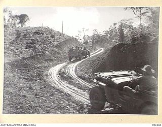 NEWTON'S KNOLL, NEW GUINEA, 1945-07-23. JEEPS PULLING TRAILERS LOADED WITH PERSONNEL GOING UP THE KNOLL BETWEEN YAMIL AND MAPRIK ON A ROAD MAINTAINED BY 2/4 FIELD REGIMENT, ROYAL AUSTRALIAN ..