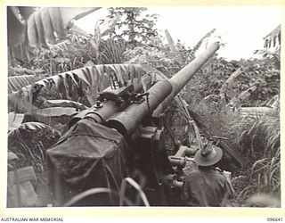 RABAUL, NEW BRITAIN. 1945-09-14. A JAPANESE 105MM ANTI-AIRCRAFT GUN MOUNTED ON A HIGH FEATURE NEAR THE FORMER GOVERNMENT HOUSE AT RABAUL. COMMANDING SUCH A STRATEGIC POSITION IT WAS A SOURCE OF ..