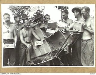 RAMU VALLEY, NEW GUINEA. 1943-12-21. MEN OF THE 2/31ST AUSTRALIAN INFANTRY BATTALION RECEIVING THEIR AUSTRALIAN COMFORTS FUND CHRISTMAS HAMPERS