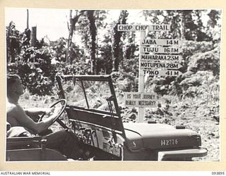 TOROKINA, BOUGAINVILLE, 1945-07-11. THE SIGNPOST AT THE SAUA RIVER ON THE CHOP CHOP TRAIL IN HEADQUARTERS 3 DIVISION AREA. THIS ROAD, RECENTLY OPENED, REPLACES A LARGE SECTION OF THE BEACH ROAD TO ..