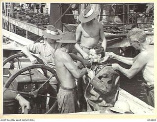 1943-05-19. NEW GUINEA. ORO BAY ALLIED SHIP SUNK BY JAPANESE BOMBS 1943-03. JOHN E. JOHNSTONE AND CAPT. J.W. HERD, SALVAGE DIVERS, (WHO HANDLED SALVAGE OF GOLD FROM THE "NIAGARA") INSPECT SUNKEN ..