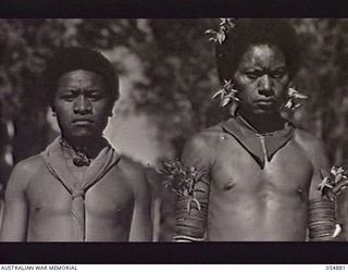 BULLDOG-WAU ROAD, NEW GUINEA, 1943-07-11. TWO NATIVE "BOSS BOYS", ONO BIO (LEFT) AND OUI AITSI WHO ARE EMPLOYED TO DISCIPLINE NATIVE BEARERS AND ROAD WORKERS