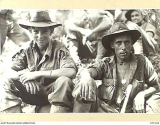 KETOBA, NEW GUINEA. 1944-01-29. Q138283 PRIVATE J. O'DONOHUE (1) AND VX13692 PRIVATE L. WATSON (2) OF 11TH PLATOON, "B" COMPANY, 57/60TH INFANTRY BATTALION RESTING ON THE TRACK AFTER HAVING ..