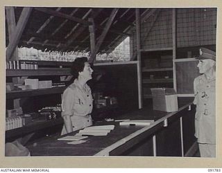 LAE, NEW GUINEA. 1945-05-14. LIEUTENANT GENERAL V.A.H. STURDEE, GENERAL OFFICER COMMANDING FIRST ARMY (2), IN THE AUSTRALIAN WOMEN'S ARMY SERVICE CANTEEN WITH CORPORAL M. FARR (1), DURING HIS ..