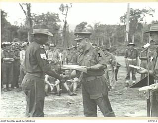 TOROKINA, BOUGAINVILLE ISLAND. 1945-01-01. TX2002 BRIGADIER J. FIELD, DSO, ED, COMMANDING OFFICER, 7TH INFANTRY BRIGADE (2) PRESENTING THE PRIZE TO THE WINNER OF THE FINAL OF THE 220 YARDS SPRINT, ..