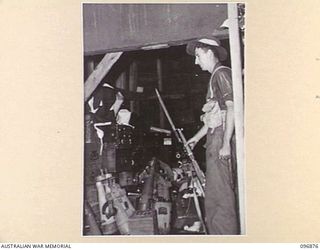 MATAPI CRATER, NEW BRITAIN, 1945-09-15. PTE T.O. MARTIN, 37/52 INFANTRY BATTALION GUARDING A JAPANESE NAVAL STORE DUMP. THE UNIT IS OCCUPYING THE AREA FOLLOWING THE JAPANESE SURRENDER