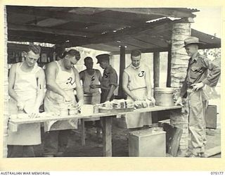 SIAR, NEW GUINEA. 1944-08-09. COOKS OF A COMPANY, 25TH INFANTRY BATTALION, SUPERVISED BY Q21901 WARRANT OFFICER II, M. OLSEN, UNIT CATERER, (4) AND NX137071 LIEUTENANT R.S. MCGOVERN, CATERING ..