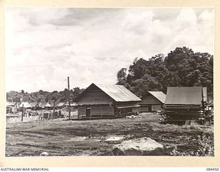 LAE, NEW GUINEA. 1944-12-21. THE OFFICERS' LINES AND MESS WITH THE SERGEANTS' MESS IN THE BACKGROUND SHOWING AREA CLEARED BY 2/3 FORESTRY COY MEMBERS AND A PORTION OF THE UNDEVELOPED CAMP SITE