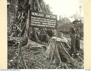 NONGARA JUNCTION, NEW GUINEA, 1944-03-17. ONE OF MANY BATTLE SIGNS IN THE FINSCHHAFEN AREA, THIS SIGN ON THE TRACK 4 MILES FROM WAREO RECORDS ACTIVITIES OF THE 29/46TH INFANTRY BATTALION. THE ..