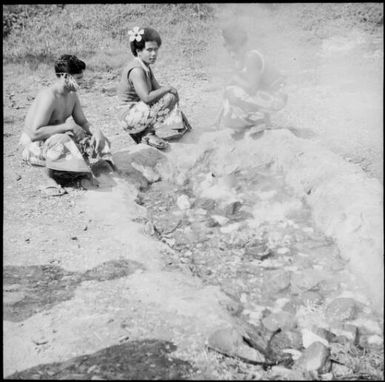 Man and two women cooking in a hot springs pool, Fiji, 1966 / Michael Terry