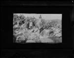 Group of approximately 13 people, on rocks.