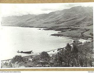 WALINGAI BEACH, NEW GUINEA. 1944-01-02. A JOIN UP VIEW OF THE BEACH SHOWING A WRECKED JAPANESE BARGE IN THE FOREGROUND WHICH WAS SUNK BY AMERICAN PT BOATS. (TO JOIN TO PHOTOGRAPH NO. 63265)