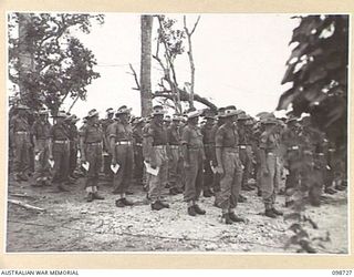 DALLMAN HARBOUR, NEW GUINEA. 1945-11-11. MEMBERS OF C COMPANY, 2/5 INFANTRY BATTALION, STAND RIGIDLY TO ATTENTION WITH BOWED HEADS FOR TWO MINUTES IN RESPECT OF FALLEN COMRADES. THEY ARE ATTENDING ..