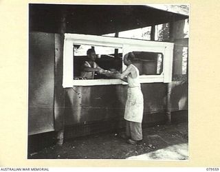 ORO BAY, NEW GUINEA. 1943-07. CORPORAL W.T.E. VEITH (1) AND PRIVATE E.G. PITTAS (2), COOKS WORKING IN THE KITCHEN OF THE 10TH FIELD AMBULANCE