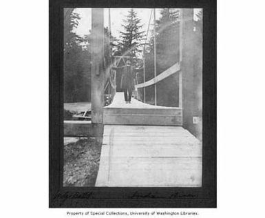 Judge Battle, possibly Nicholas W. Battle, standing on bridge over Indian River, Sitka, Alaska, probably between 1890 and 1940