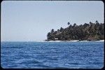 Kaileuna Island: distant view of village, beach, and palm trees