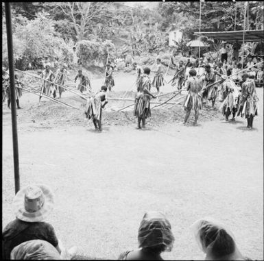 Fijian men, dressed in traditional costumes, smoothing out stones in the fire, Fiji, 1966 / Michael Terry