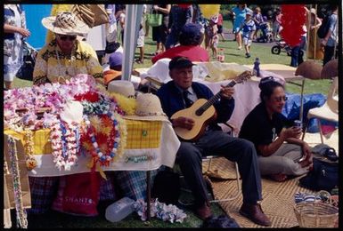 A man plays the guitar at a Niuean stall at the Pasifika Festival, Western Springs