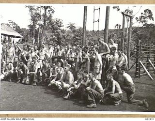 THORPVILLE, NEW GUINEA. 1943-12-07. PATIENTS POSE FOR THEIR PHOTOGRAPH IN THE OPEN AIR GYMNASIUM OF THE PHYSIOTHERAPY SECTION, 113TH AUSTRALIAN CONVALESCENT DEPOT, ON THE BANK OF THE EWOROGO CREEK