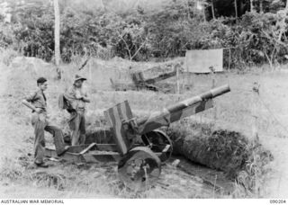 GOODENOUGH ISLAND, NEW GUINEA. 1942-10. FIELD GUNS MADE OF WOOD, TIN AND HESSIAN WERE PART OF THE BLUFF AND DECEPTION PRACTICED BY A SMALL GROUP OF AUSTRALIANS WHO SEIZED THE ISLAND AND CONVINCED ..