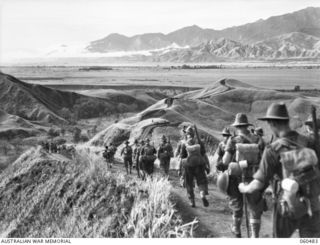 RAMU VALLEY AREA, NEW GUINEA. 1943-11-09. UNITS OF THE 21ST AUSTRALIAN INFANTRY BRIGADE MARCHING ALONG A WINDING TRACK IN THE FOOTHILLS OF THE FINISTERRE RANGES ON THEIR WAY TO THE RAMU VALLEY ..