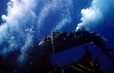 Drydock shelter (DDS) capable crewmen use a SCUBA bottle to fill the collapsable rigid rubber craft (CRRC) with air and release it to the surface from the nuclear-powered submarine USS KAMEHAMEHA (SSN-642) during duel shelter special operations training off Oahu, Hawaii