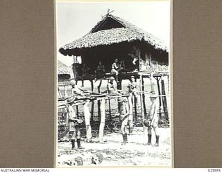 PAPUA, NEW GUINEA. 1942-07-20. AUSTRALIAN TROOPS LAYING BARBEDWIRE ENTANGLEMENTS AMONG THE "STILTS" OF A NATIVE VILLAGE