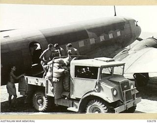 PAPUA. 1942-08-19. LOADING A DOUGLAS C47 DAKOTA AIRCRAFT WITH SUPPLIES FOR TROOPS IN THE FORWARD AREA. FOR TROOPS NEAR KOKODA, SUPPLIES ARE DROPPED FROM THE AIRCRAFT. THE GROUND TROOPS HAVE ..