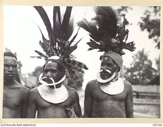 LAE, NEW GUINEA. 1945-09-07. CHIMBU CHIEFS AND AN AUSTRALIAN NEW GUINEA ADMINISTRATIVE UNIT NATIVE ATTENDANT ON ARRIVAL AT HEADQUARTERS FIRST ARMY. THE CHIEFS ARRIVED TO PAY THEIR RESPECTS TO THE ..