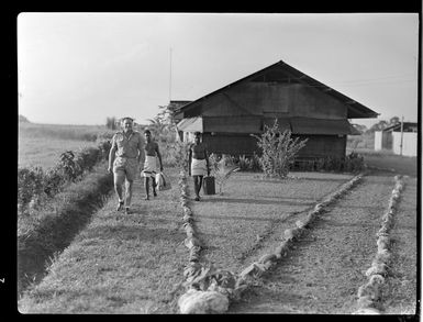 Qantas Empire Airways' catering officer, Mr B Tilbrook, with two local employees, Lae, Morobe, Papua New Guinea