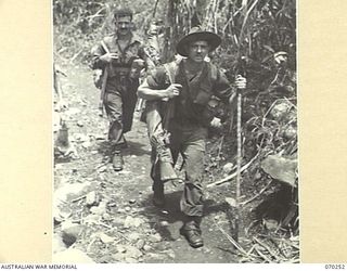 FARIA VALLEY, NEW GUINEA, 1944-02-09. SX10654 CORPORAL J. BARRIE OF THE 2/10TH INFANTRY BATTALION TRAVELLING DOWN THE TRACK FROM KANKIRYO ALONG THE FARIA RIVER TO GUY'S POST