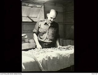 NADZAB, NEW GUINEA. 1944-05-09. CORPORAL M. TOSH OF SYDNEY, NSW, CHECKS INSTRUMENTS IN THE OPERATING THEATRE AT NO. 23 MEDICAL CLEARING STATION RAAF, WHICH IS ABSOLUTELY ANTISEPTIC AND FLY-PROOF