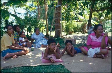 Group sitting on mats under trees
