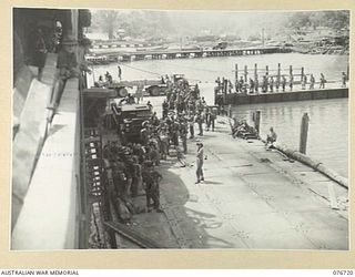 MILFORD HAVEN, LAE, NEW GUINEA. 1944-11-01. TROOPS OF HEADQUARTERS, 3RD DIVISION LINED UP ON THE FLOATING WHARF AT MILFORD HAVEN PRIOR TO THEIR EMBARKATION ABOARD THE AMERICAN LIBERTY SHIP, LINDLEY ..