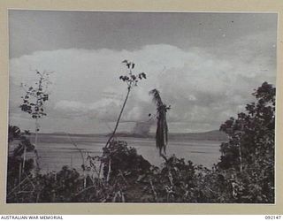 CAPE WOM, WEWAK AREA, NEW GUINEA. 1945-05-09. A SCENE FROM HEADQUARTERS 6 DIVISION AREA SHOWING SMOKE RISING FROM WEWAK POINT DURING A BLITZ BY RAAF BEAUFORTS THE DAY BEFORE OUR TROOPS ATTACKED THE ..