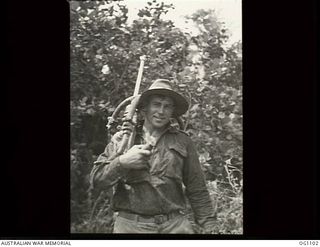AITAPE, NORTH EAST NEW GUINEA. C. 1944-06. NOT A MACHINE GUN: CORPORAL A. J. WHYTE, QLD, A RAAF POWDER MONKEY, SHOULDERS HIS PNEUMATIC DRILL AFTER PREPARING FOR BLASTING. HIS HAS BEEN DRILLING ..