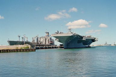 Port bow view of the Military Sealift Command (MSC) replenishment oiler USNS GAUDALUPE (T-AO 200) at berth H-1 and the nuclear-powered aircraft carrier USS ABRAHAM LINCOLN (CVN 72) tied up at the Hotel H3:H4 pier at Pearl Harbor. The ships are here taking part in Operation RIMPAC 2000