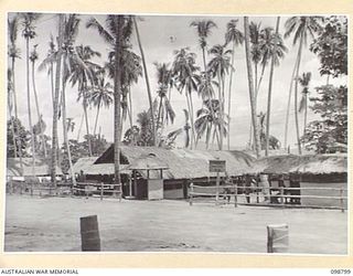 KERAVIA BAY, NEW BRITAIN. 1945-11-12. THE FRONT ENTRANCE TO THE ROYAL NETHERLANDS EAST INDIES ARMY CAMP WHERE SOME 150 ROYAL NETHERLANDS EAST INDIES EX-PRISONERS OF WAR ARE AWAITING MOVEMENT TO ..