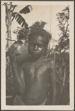 Young Papuan boy holding a gourd, New Britain Island, Papua New Guinea, probably 1916