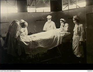 Port Moresby, New Guinea. 1944-05-29. A team at the 2/1st Australian General Hospital performing and assisting with an operation. Left to right: Lieutenant Colonel C. A. M. Renau, ..