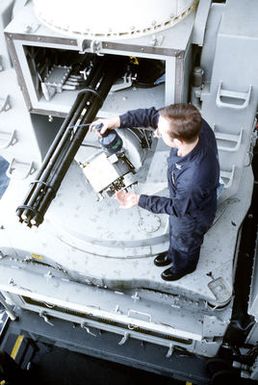 A fire control technician performs preventive maintenance on one of the 20mm Mark 15 Phalanx close-in weapons systems (CIWS) on the amphibious assault ship USS GUAM (LPH-9)