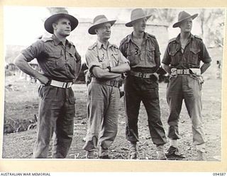 SIPILANGAN, NEW BRITAIN, 1945-07-27. OFFICERS OF AUSTRALIAN ARMY SERVICE CORPS IN CONFERENCE WITH AN AUSTRALIAN NEW GUINEA ADMINISTRATIVE UNIT OFFICER REGARDING SUPPLIES FOR REFUGEE NATIVES AT AN ..