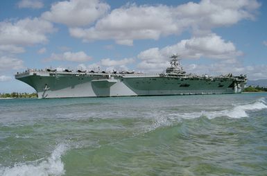 Port side view of the nuclear-powered aircraft carrier USS ABRAHAM LINCOLN (CVN 72) moving out of the channel at Pearl Harbor en route to take part in Operation RIMPAC 2000 to the south of the Hawaiian Islands