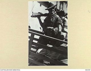 CAIRNS, QLD. 1944-10-28. PRIVATE GLEESON, C COMPANY, 2/4 INFANTRY BATTALION, BOARDING THE USS MEXICO DURING EMBARKATION FOR NEW GUINEA