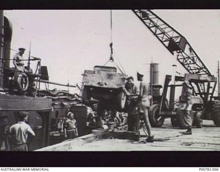 FINSCHHAFEN, NEW GUINEA, 1944-05. RAN PERSONNEL OF HMAS CASTLEMAINE LOADING A JEEP FOR TRANSPORTATION TO MADANG. (DONOR: J. DEEBLE)